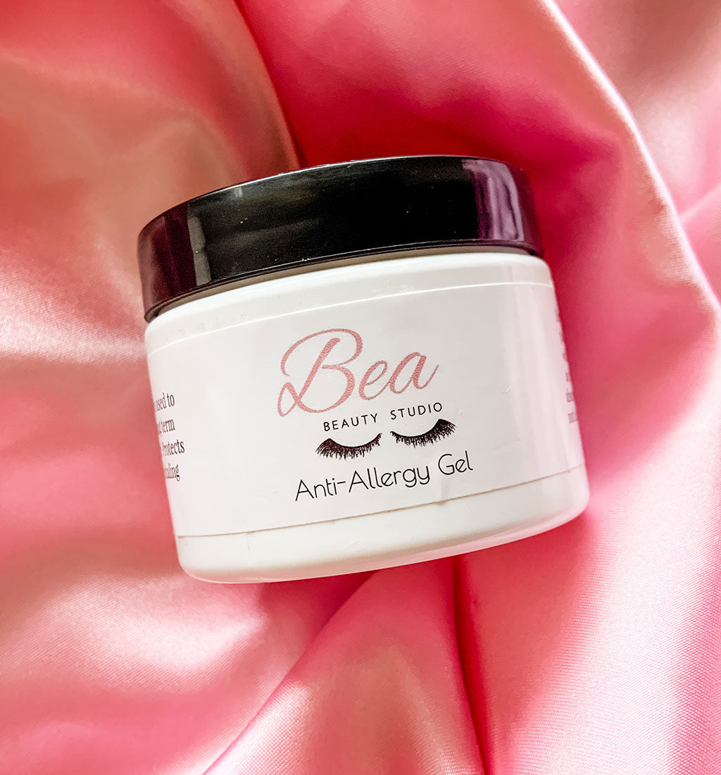 Side view of Bea Beauty Studio&#39;s Anti-Allergy Gel jar on pink satin background.