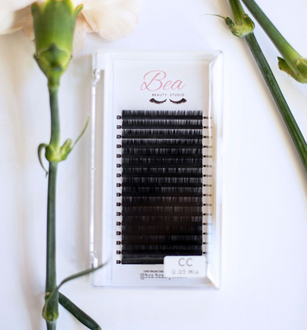 CC Curl Lash Tray .18 lash tray surrounded by flowers on a white background.