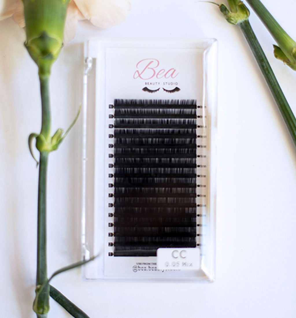 CC Curl Lash Tray .05 lash tray surrounded by flowers on a white background.