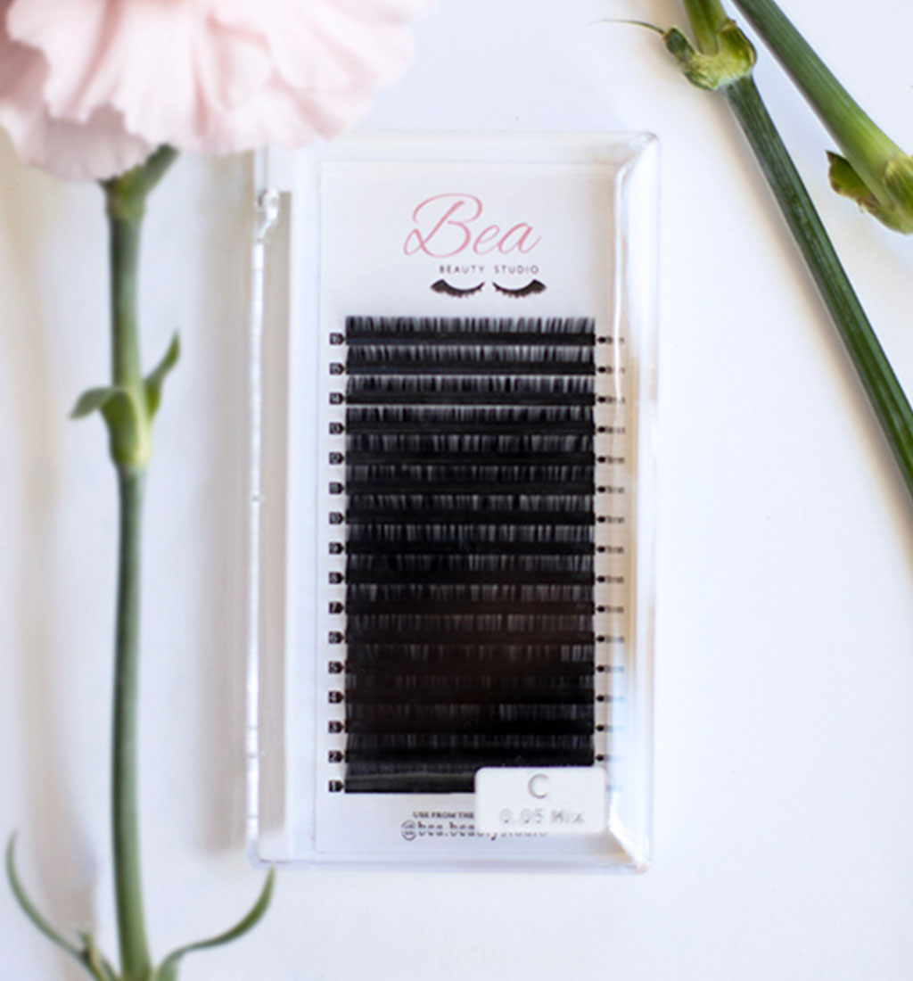 C Curl Lash Tray .18 lash tray surrounded by flowers on a white background.