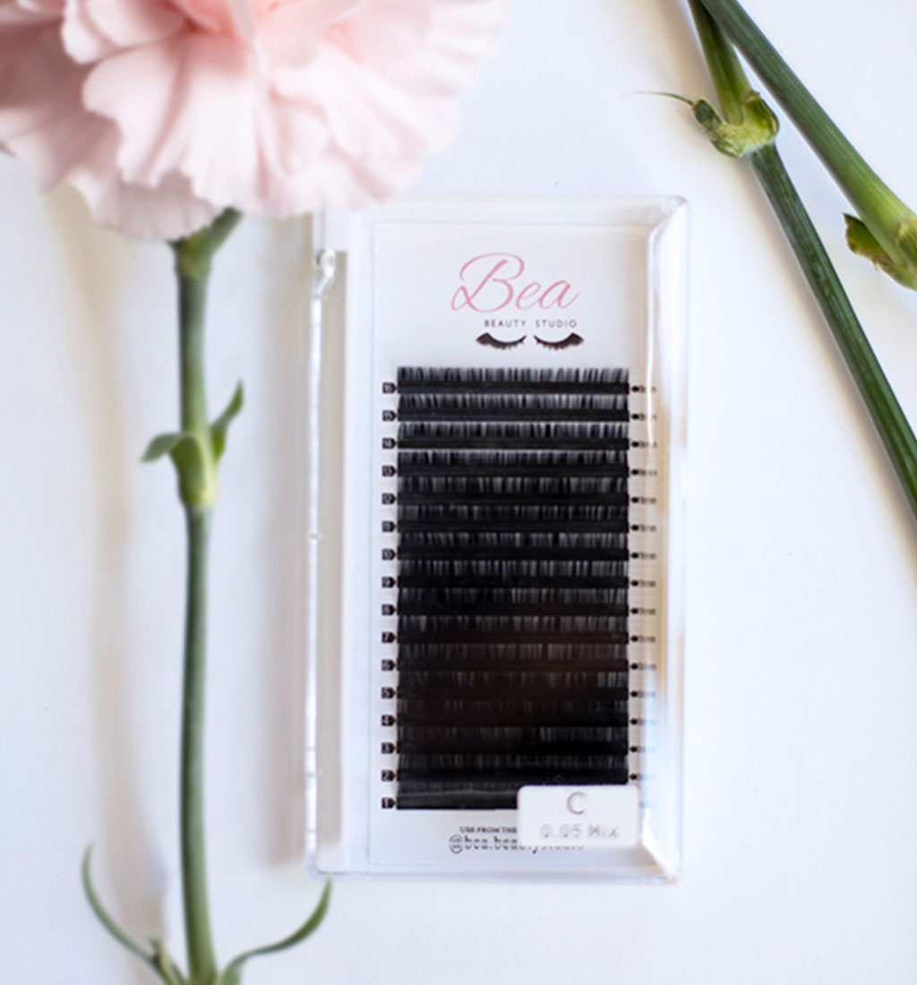 C Curl Lash Tray .05 lash tray surrounded by flowers on a white background.