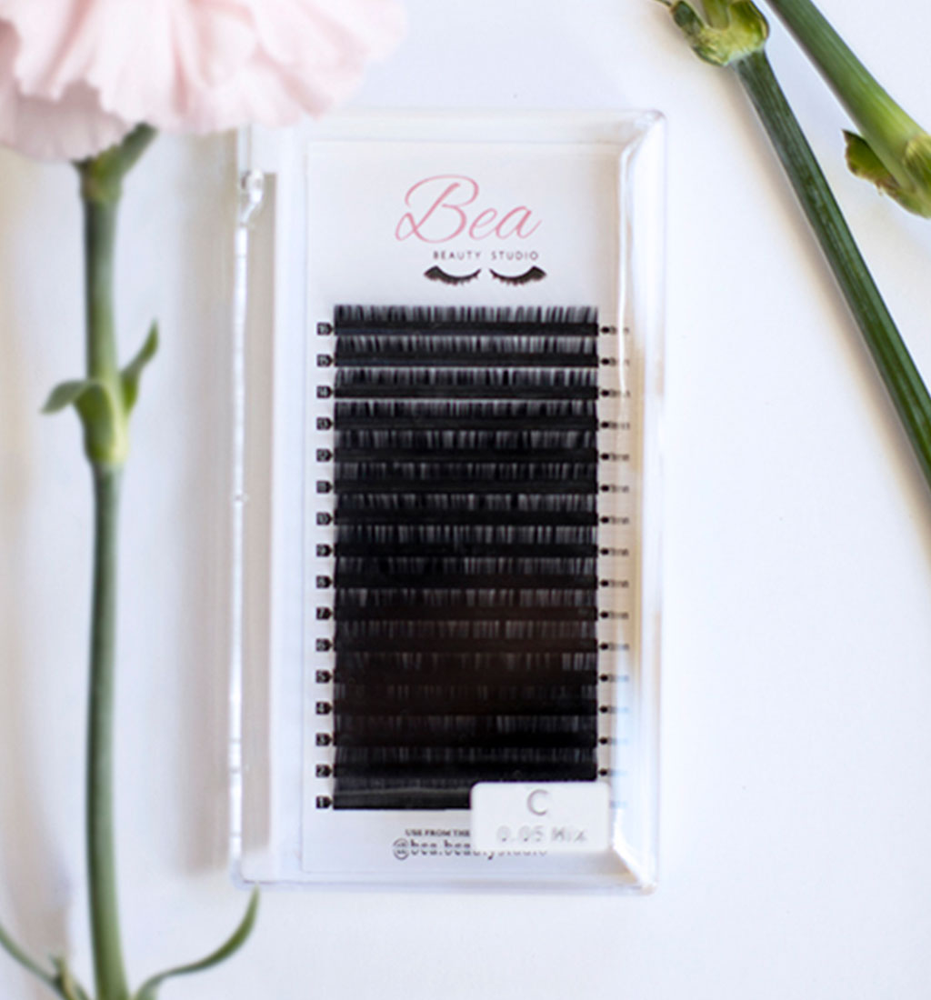 C Curl Lash Tray .07 lash tray surrounded by flowers on a white background.