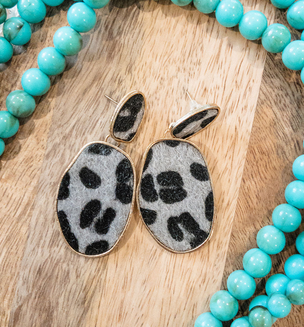 Cheetah print earrings in grey and black pattern with gold hardware.