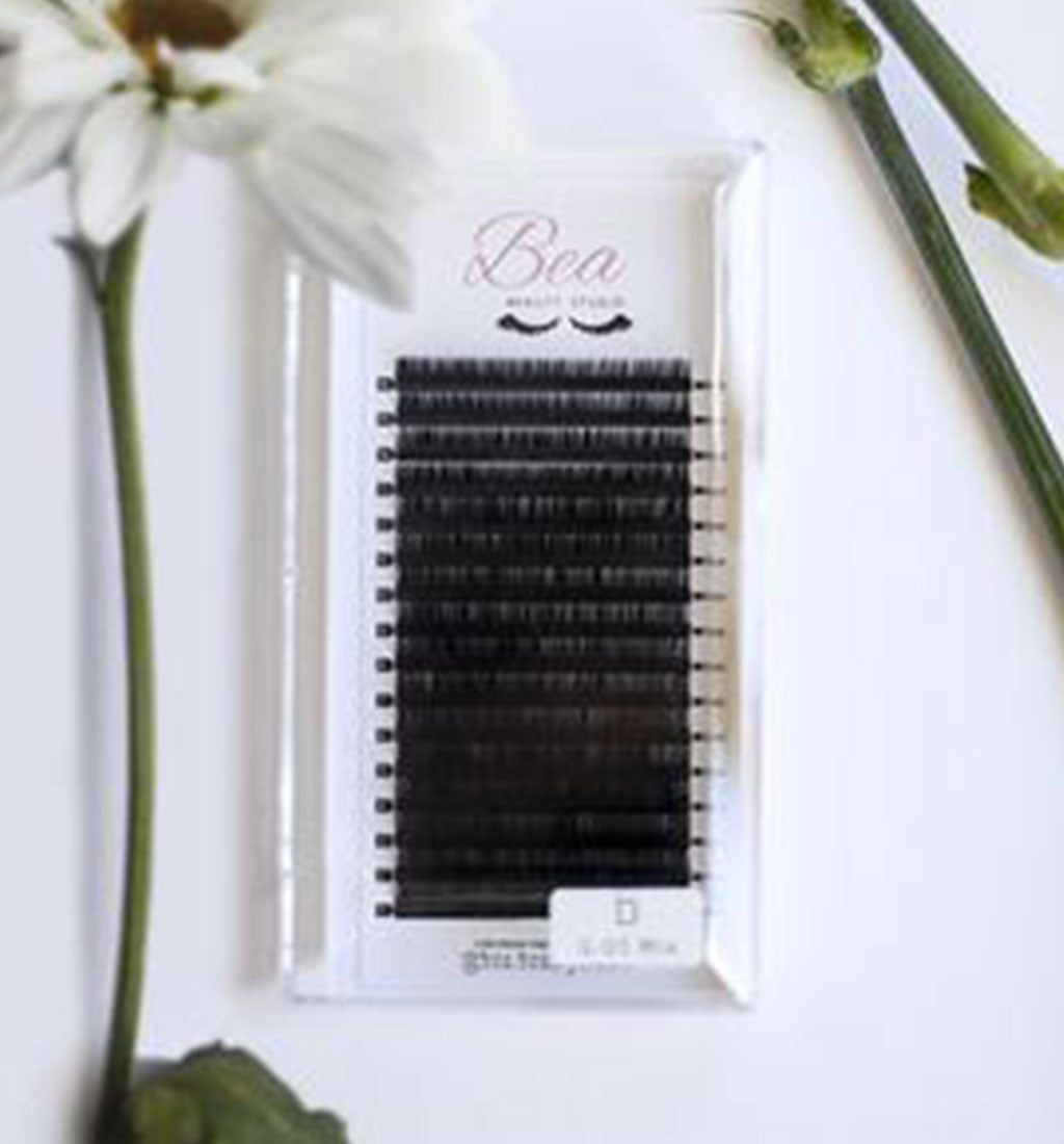 D Curl Lash Tray .05 on a white background  surrounded by flowers.