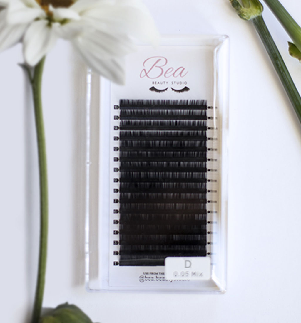 D Curl Lash Tray .07 on a white background  surrounded by flowers.