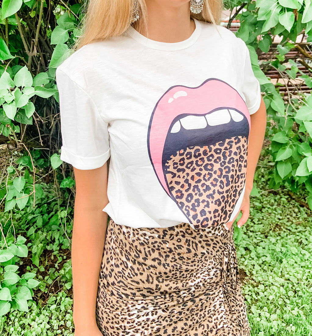 A young woman wearing a fashionable cheetah print drawstring skirt with a matching t-shirt.
